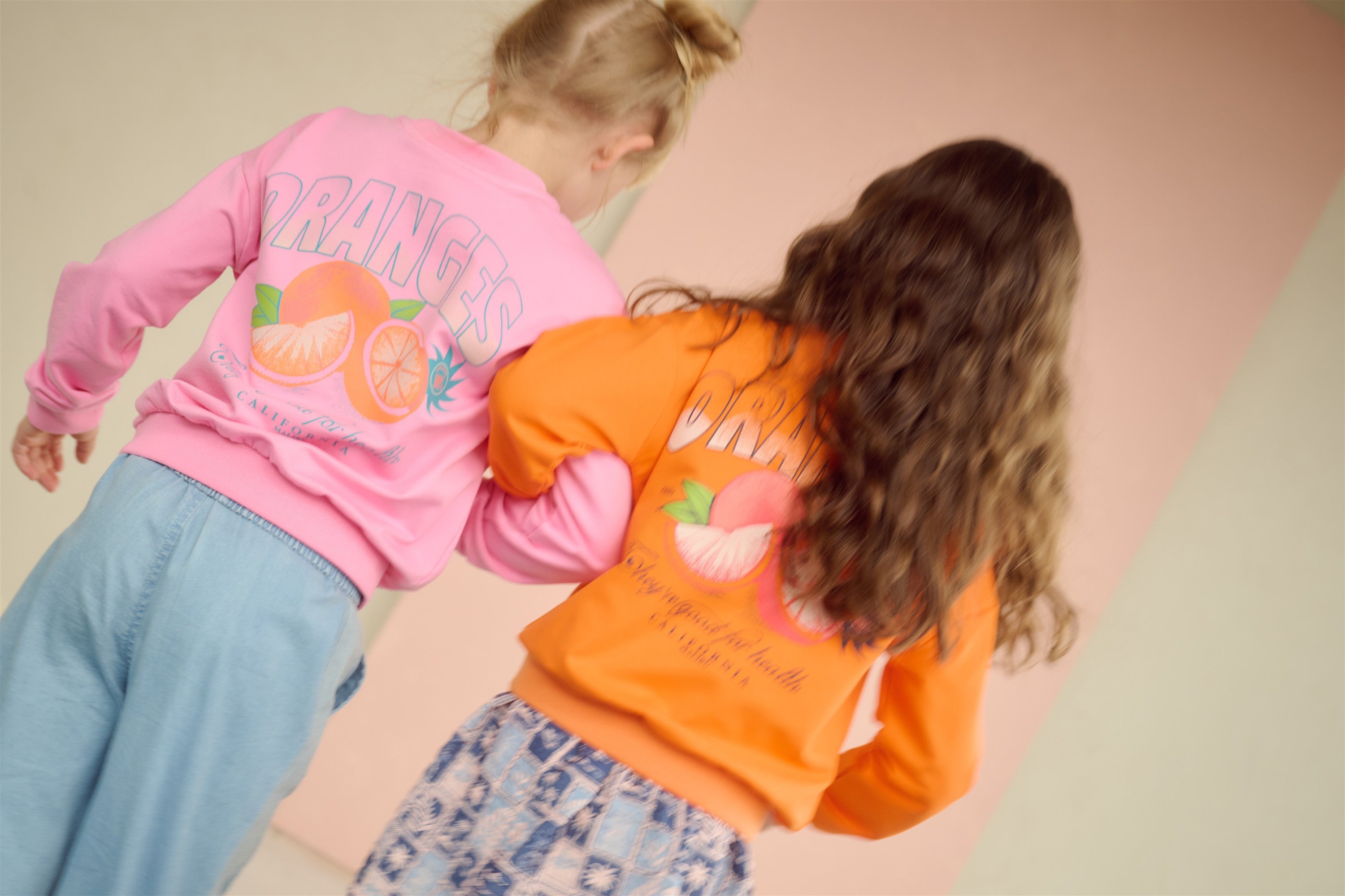 Konono Sweater met Orange rugprint Roze